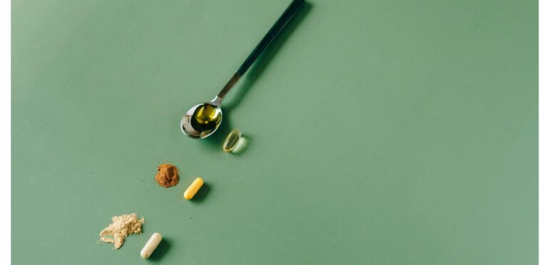 L'image présente une cuillère avec trois vitamines qui sont des suppléments.